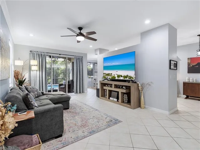 a living room with furniture a flat screen tv and a floor to ceiling window
