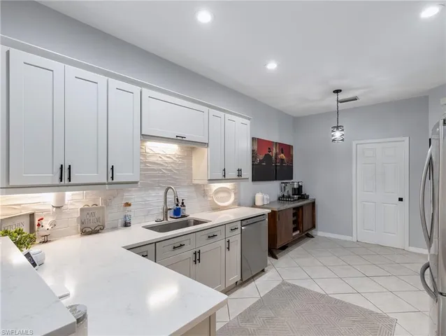 a kitchen with stainless steel appliances a stove top oven a sink a refrigerator and cabinets