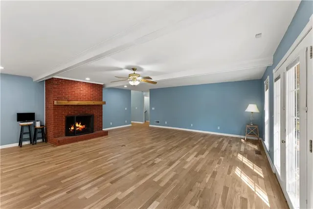 a view of an empty room with a fireplace and a window