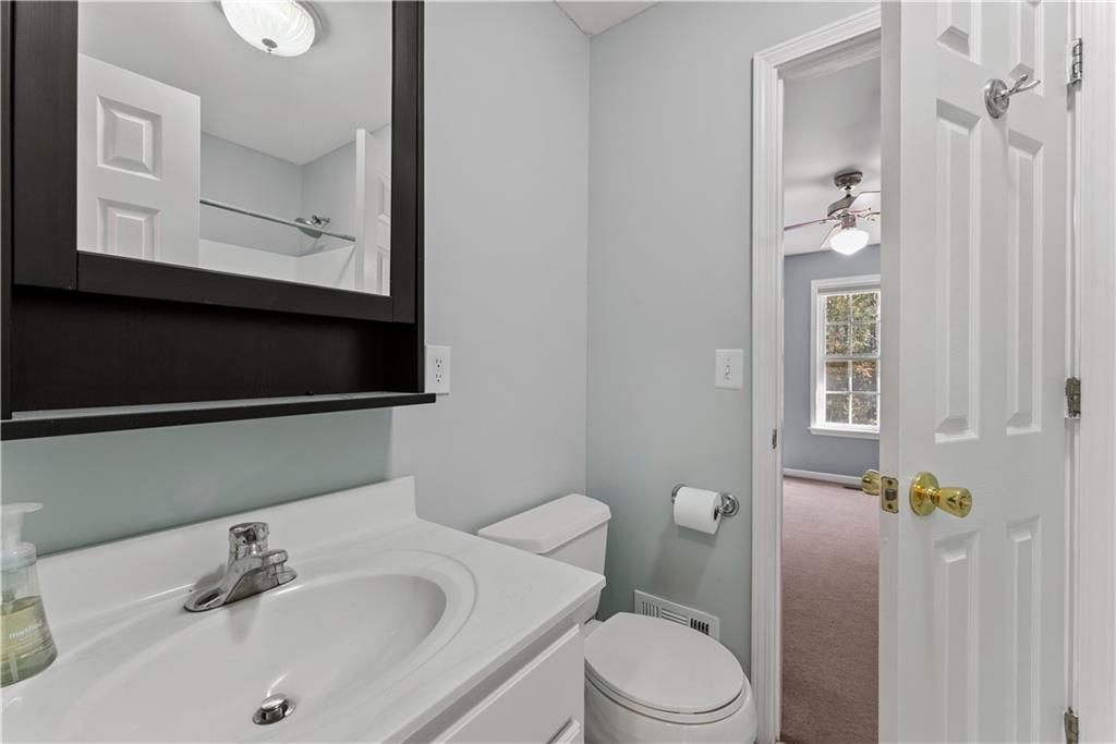 5478 Flakes Mill Road Ellenwood, GA 30294 - Photo 9 of 30 a bathroom with a sink vanity granite toilet and a mirror