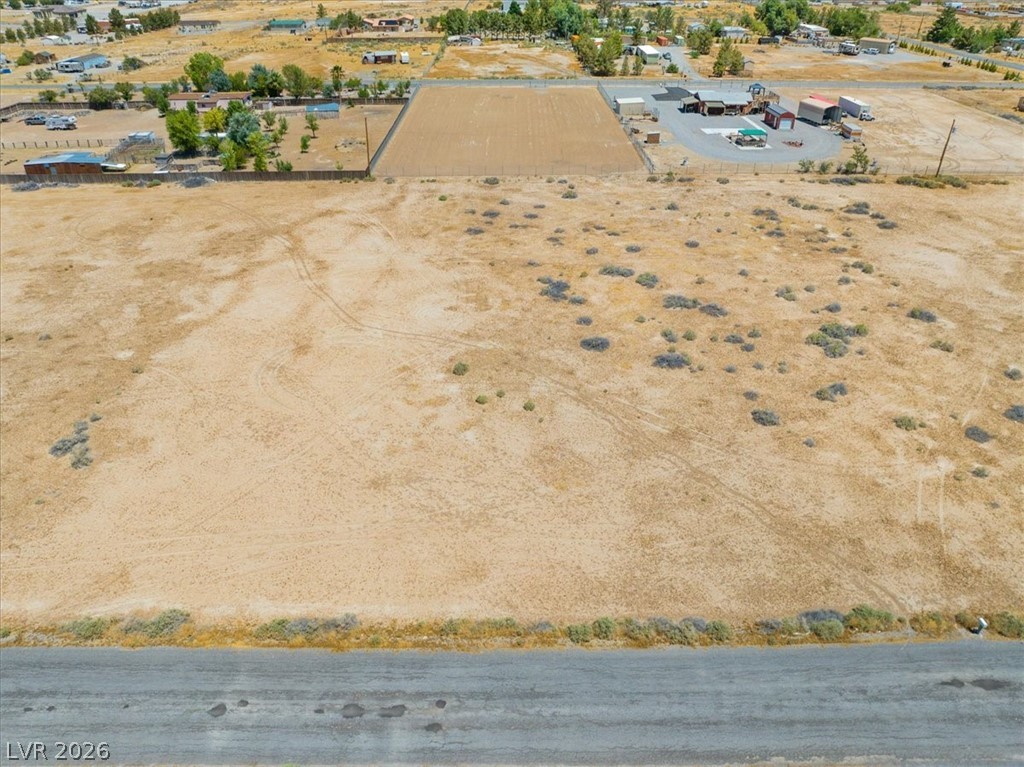 4610 Lawrence Road Pahrump, NV 89048 - Photo 21 of 42 A vast, level parcel of land presents a clear canvas for development, bordering a residential cluster.