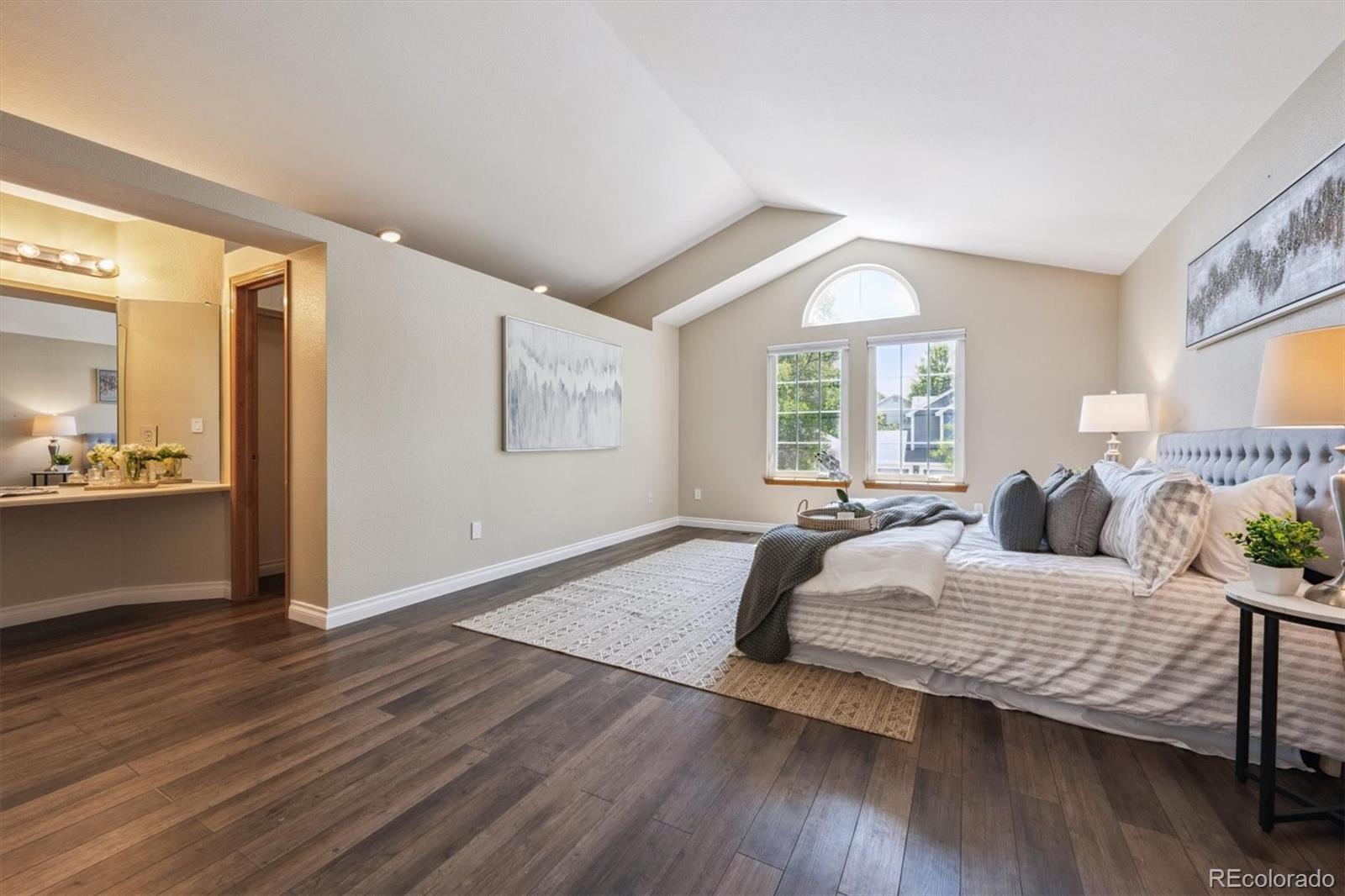 6715 West 97th Circle Westminster, CO 80021 - Photo 16 of 31 a bedroom with a large bed and wooden floor