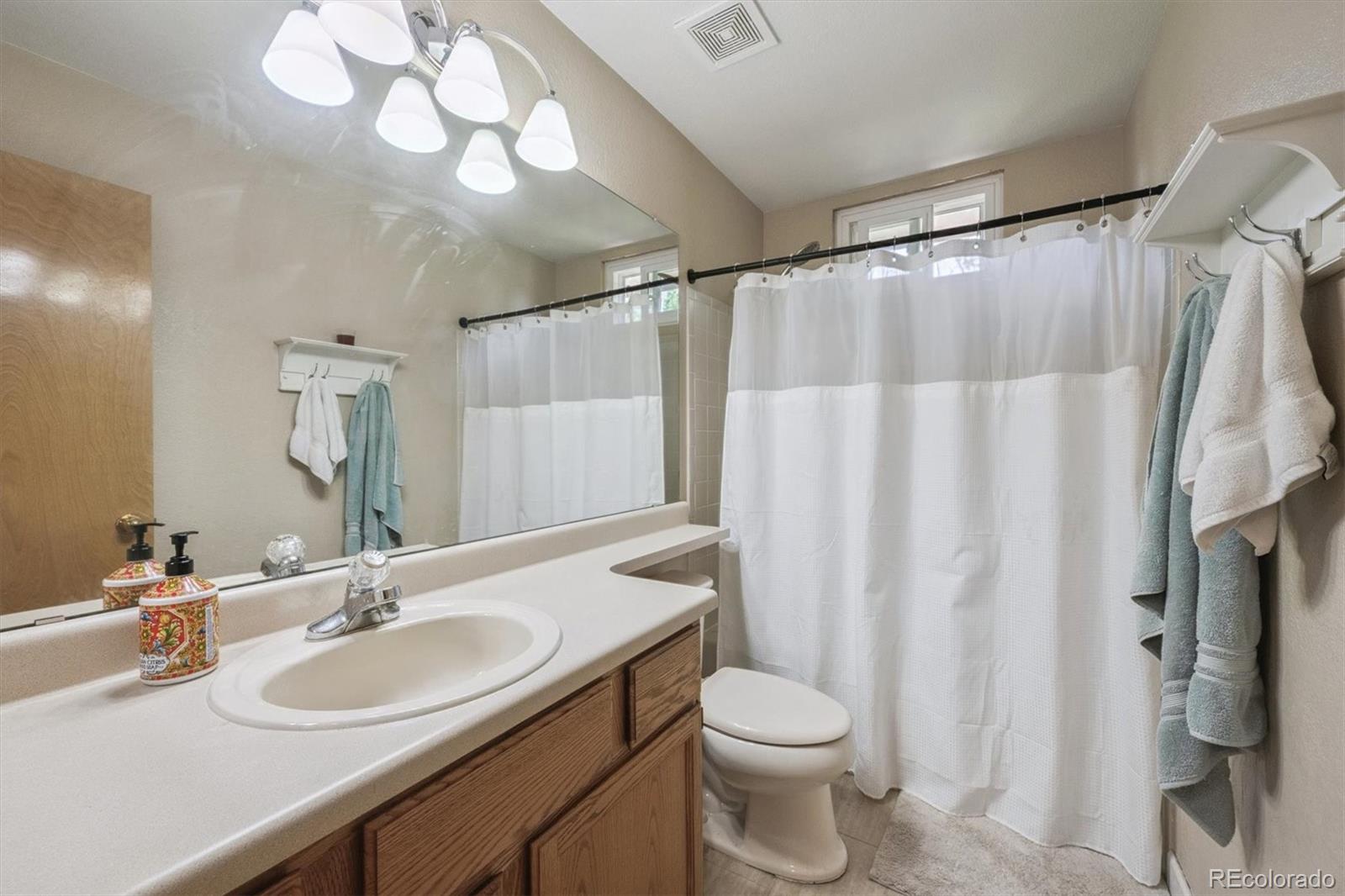6715 West 97th Circle Westminster, CO 80021 - Photo 22 of 31 a bathroom with a sink vanity mirror and toilet