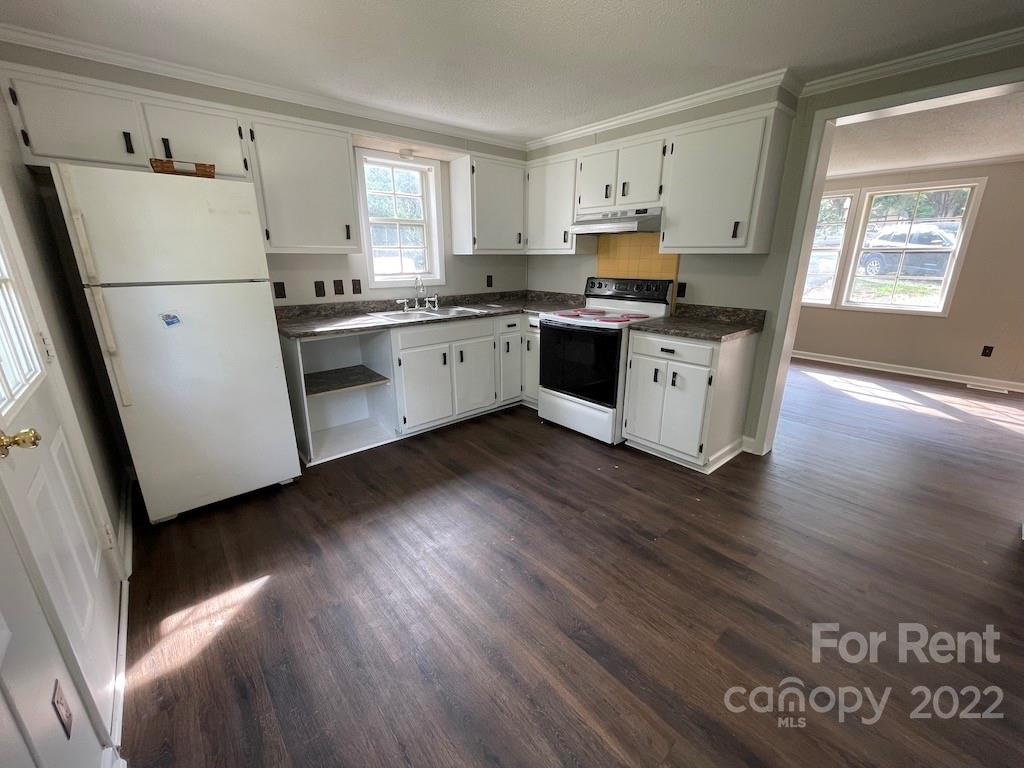 56 Barbee Road Southwest, Unit 1A Concord, NC 28027 - Photo 4 of 9 a kitchen with granite countertop white cabinets and white appliances