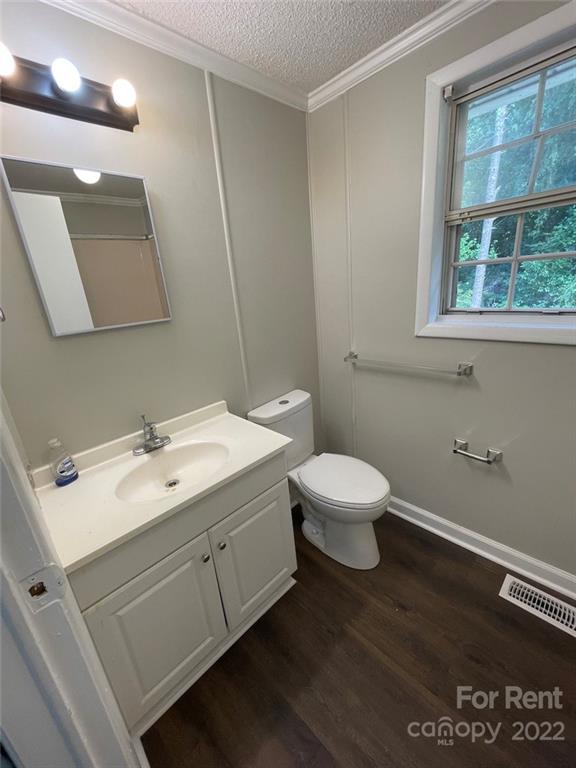 56 Barbee Road Southwest, Unit 1A Concord, NC 28027 - Photo 5 of 9 a bathroom with a toilet sink and mirror