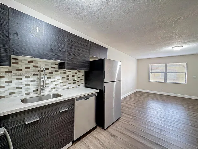 a kitchen with stainless steel appliances a refrigerator sink and stove