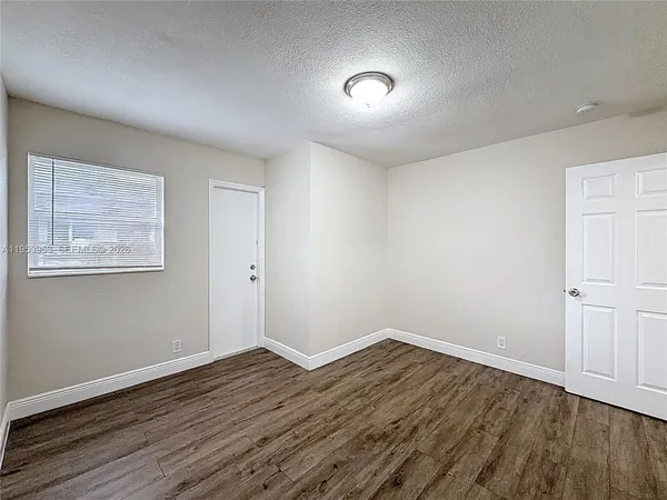 a view of an empty room with wooden floor
