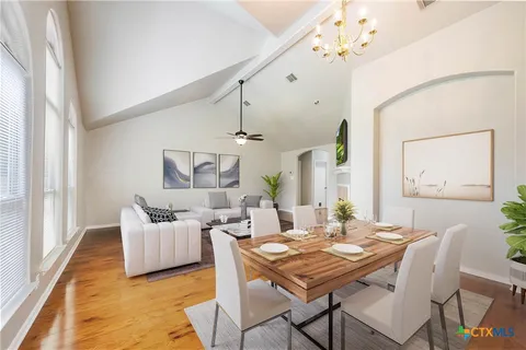 a dining room with furniture a chandelier and wooden floor