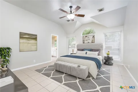 a bedroom with a large bed and a chandelier