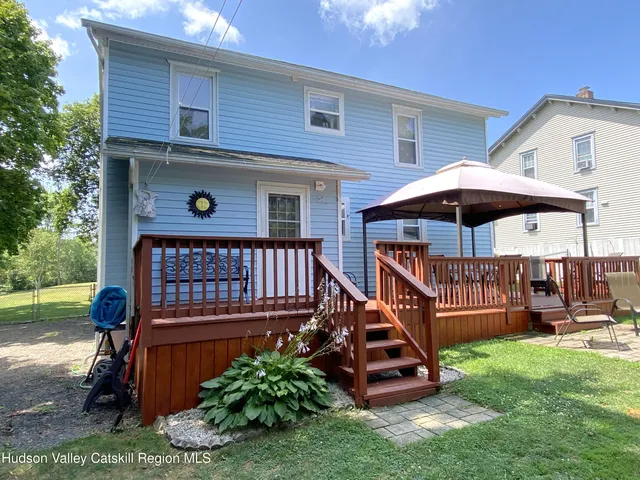 a view of a house with a backyard and swimming pool