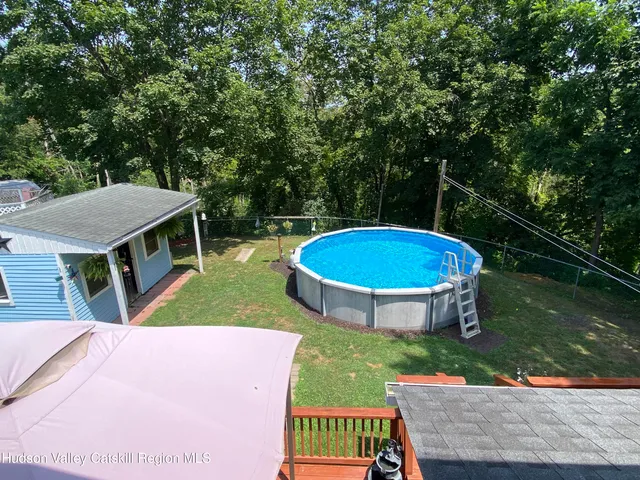 a view of a chairs and table on the wooden roof deck