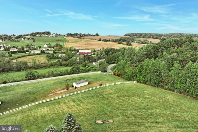 a view of a green field with trees in the background