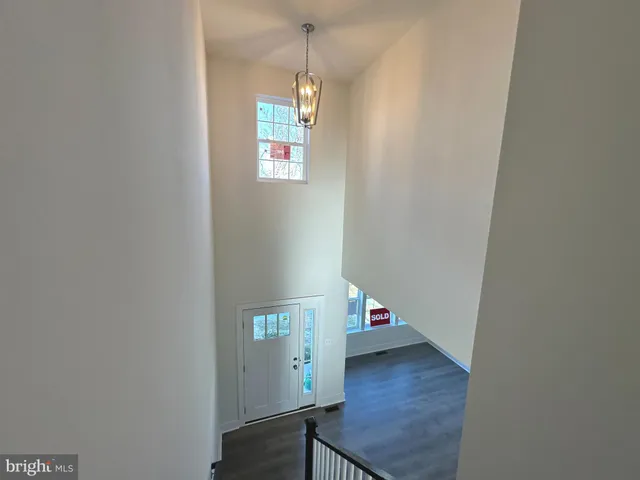 a view of a hallway with wooden floor and a window