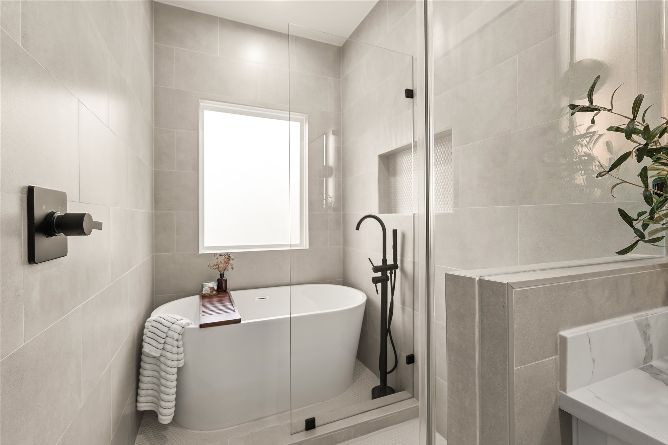 3539 Mainer Street, Unit B Houston, TX 77021 - Photo 19 of 29 Freestanding soaking tub, matte black floor-mount filler, and a built-in tiled niche