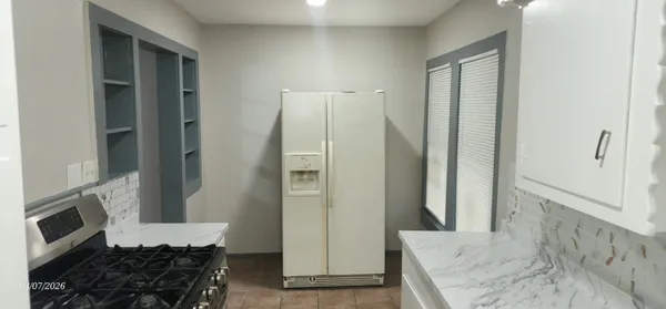 a kitchen with stainless steel appliances granite countertop a refrigerator and a stove