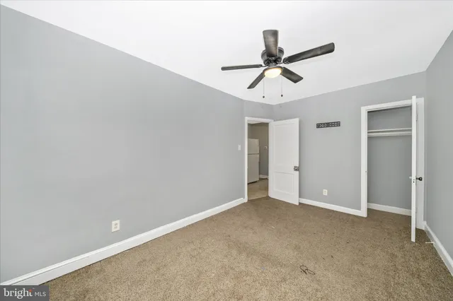 an empty room with closet and windows