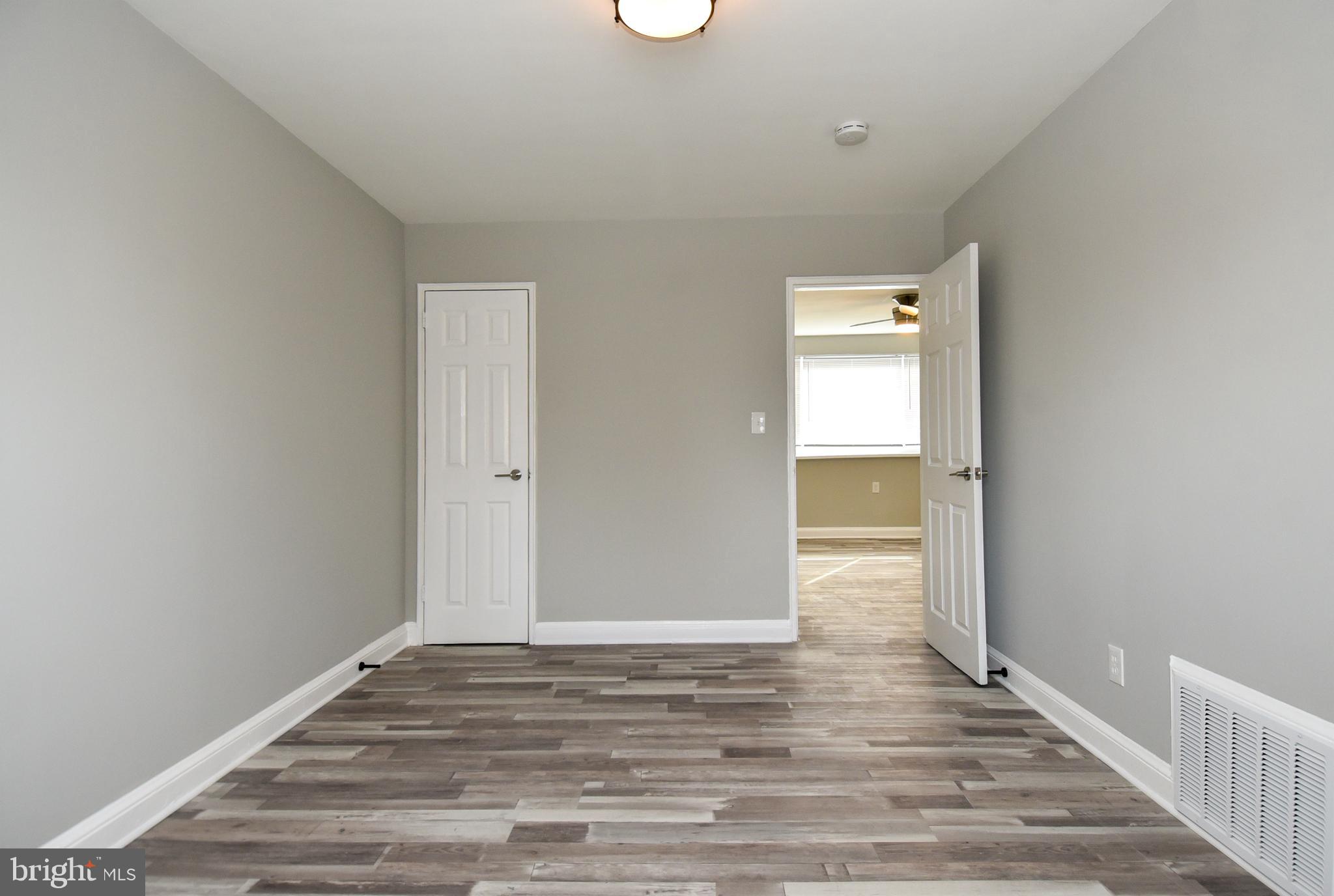 8208 Bellefonte Lane, Unit 3 Clinton, MD 20735 - Photo 14 of 18 a view of an empty room with wooden floor and a window