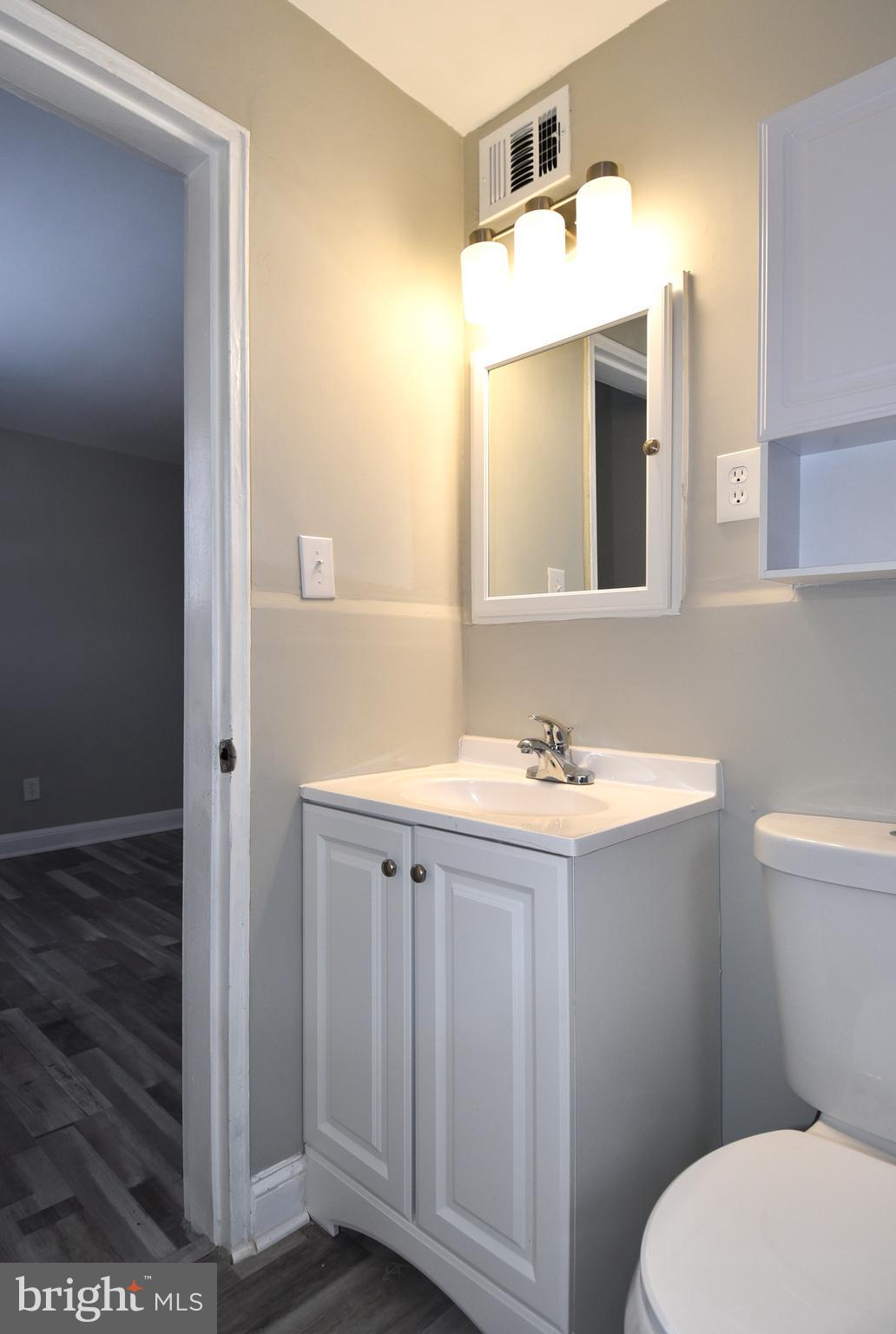 8208 Bellefonte Lane, Unit 3 Clinton, MD 20735 - Photo 17 of 18 a bathroom with a sink a toilet a mirror and vanity