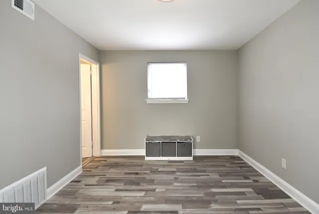 a view of a livingroom with wooden floor and a window