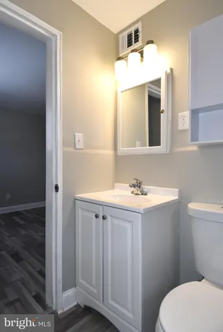 a bathroom with a sink a toilet a mirror and vanity