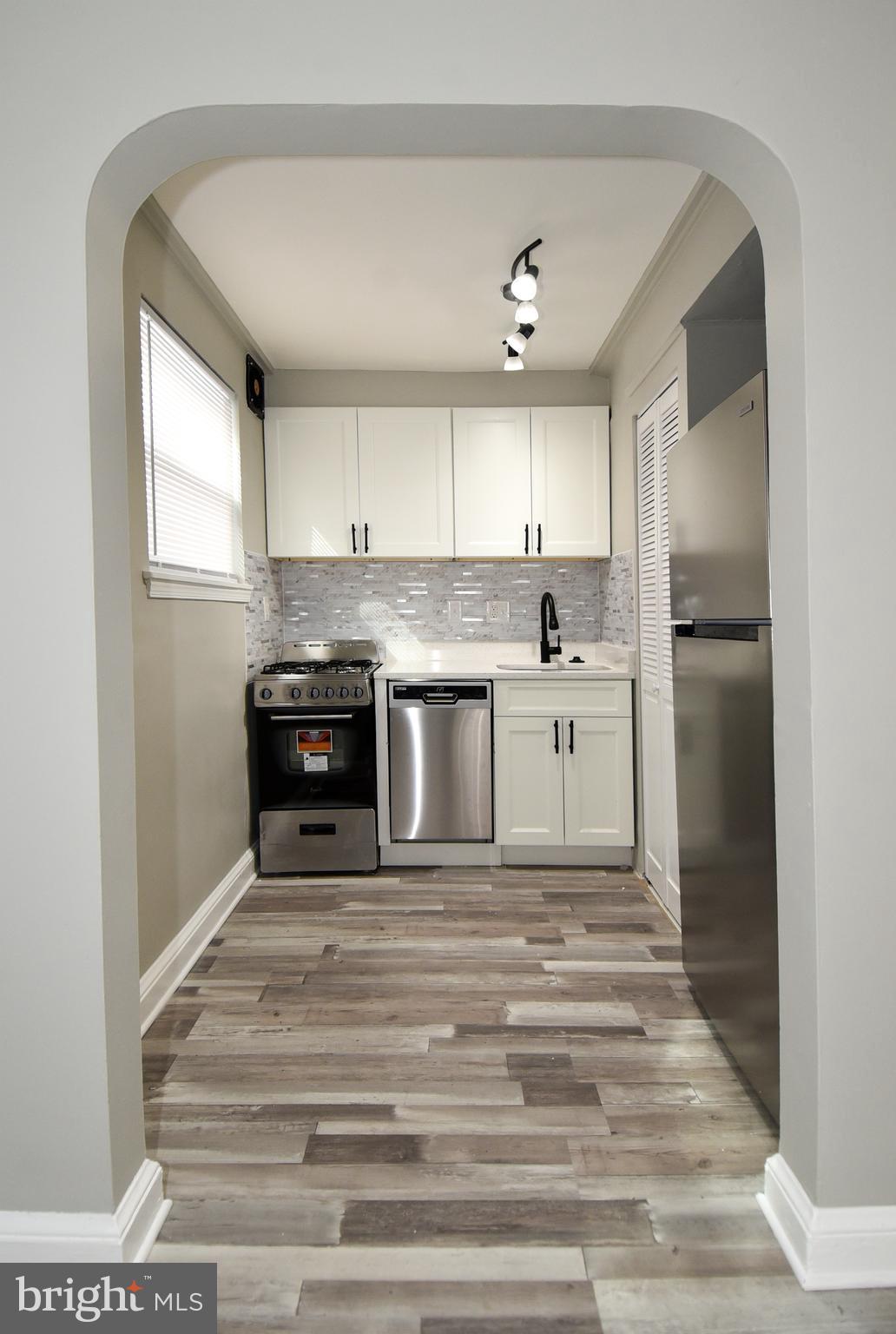 8208 Bellefonte Lane, Unit 3 Clinton, MD 20735 - Photo 6 of 38 a kitchen with kitchen island a sink stainless steel appliances and cabinets