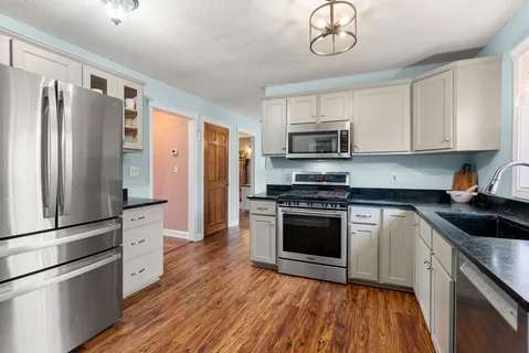 a kitchen with stainless steel appliances granite countertop a refrigerator stove and sink