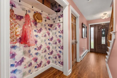 a view of a hallway with wooden floor and front door