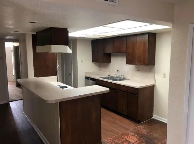 a kitchen with a sink cabinets and a wooden floor