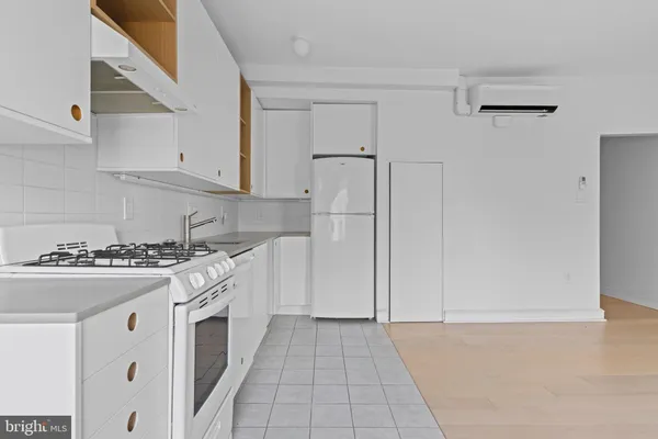 a kitchen with stainless steel appliances a stove a refrigerator and white cabinets