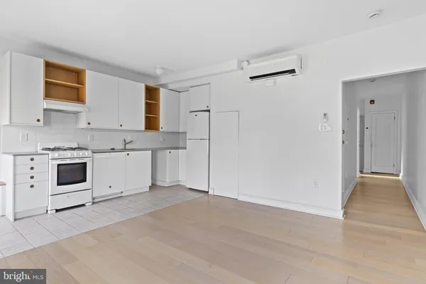 a kitchen with white cabinets and white appliances