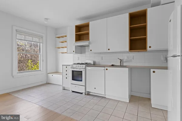 a kitchen with white cabinets and white appliances