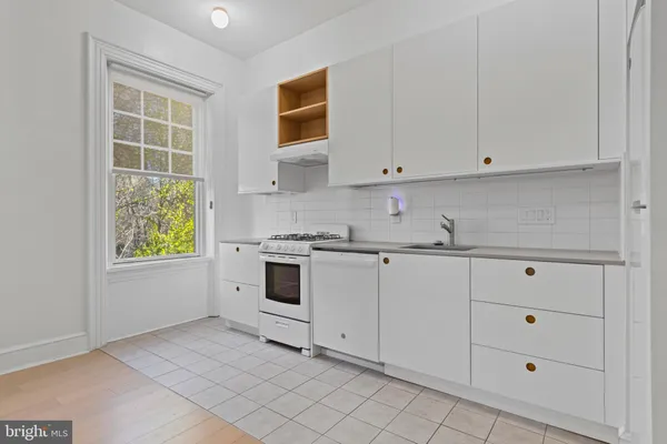 a kitchen with white cabinets and white appliances