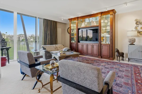 a living room with furniture and a floor to ceiling window