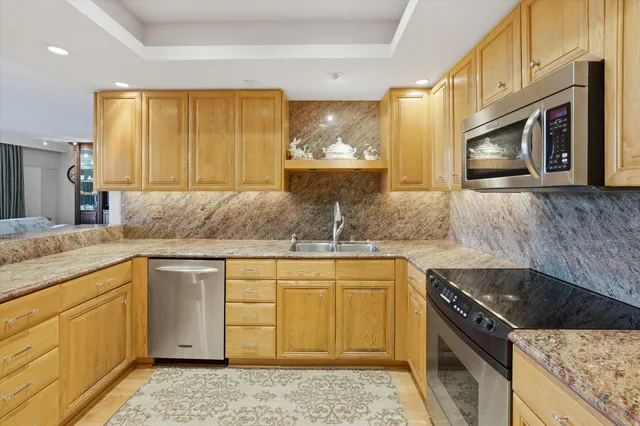 a kitchen with stainless steel appliances granite countertop a sink stove and cabinets