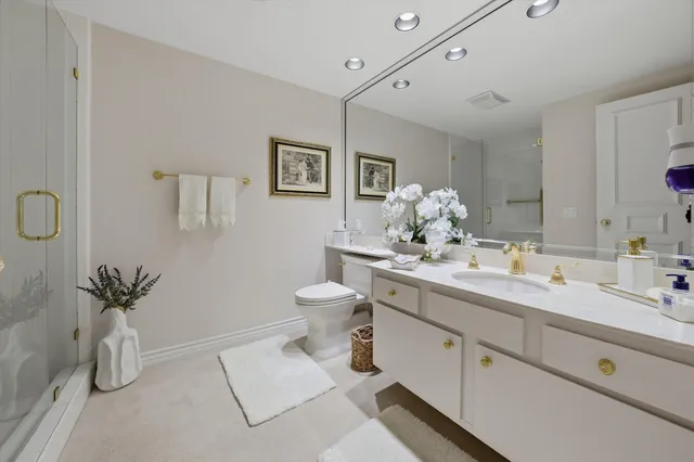 a spacious bathroom with a granite countertop sink a toilet and a mirror