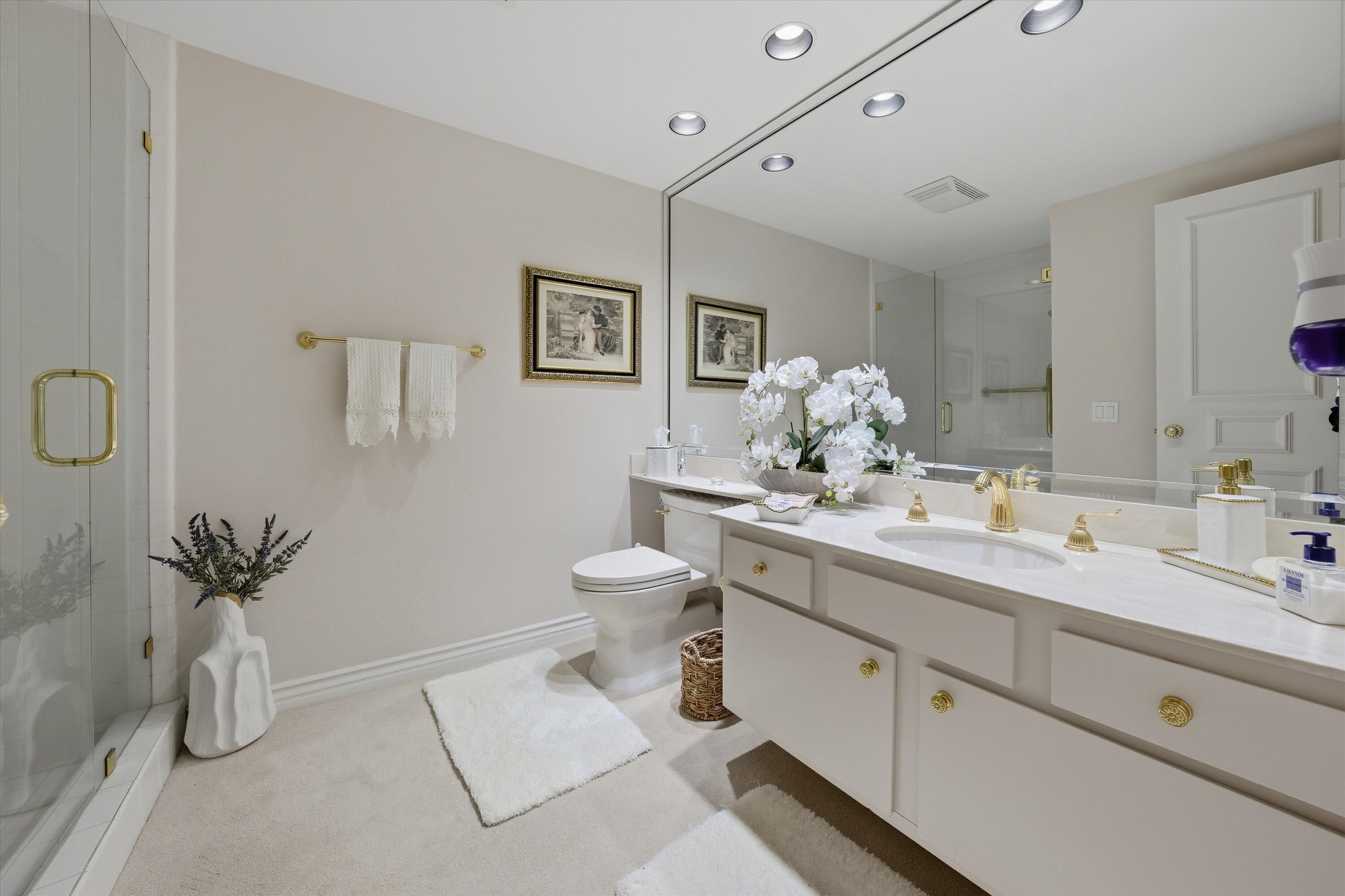 900 Island Drive, Unit 304 Rancho Mirage, CA 92270 - Photo 26 of 40 a spacious bathroom with a granite countertop sink a toilet and a mirror