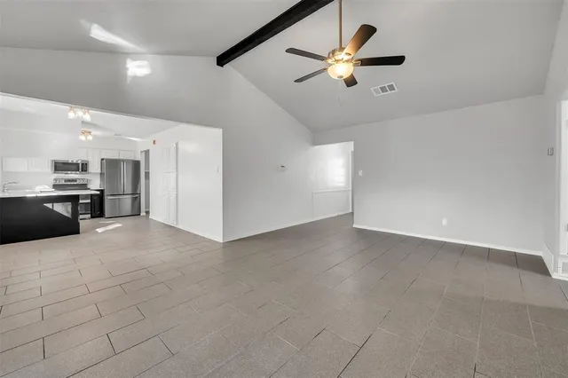 a view of a livingroom with a ceiling fan and kitchen view
