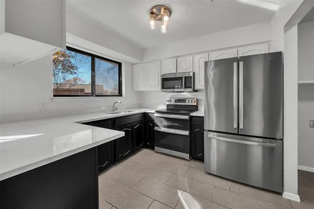 a kitchen with kitchen island a counter appliances a sink and cabinets