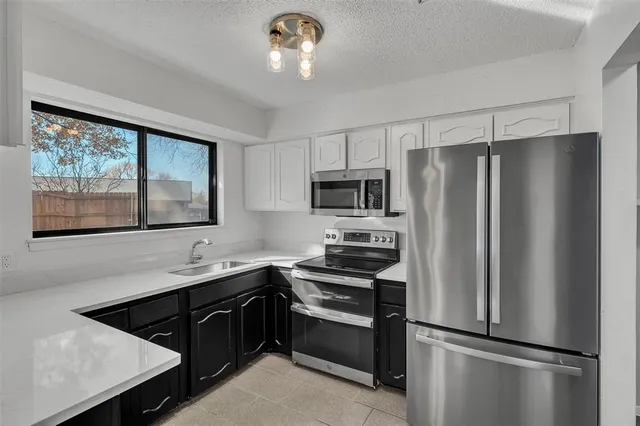 a kitchen with stainless steel appliances a refrigerator sink and microwave