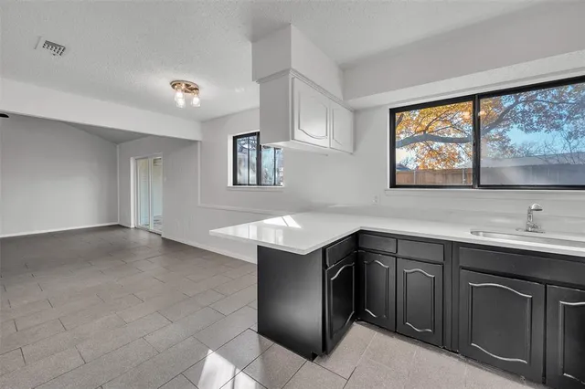 a kitchen with a sink cabinets and window