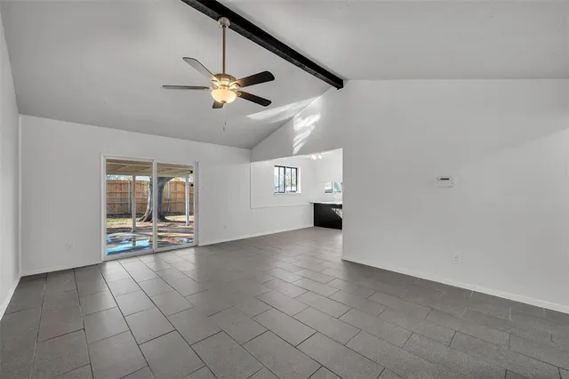 an empty room with windows and ceiling fan