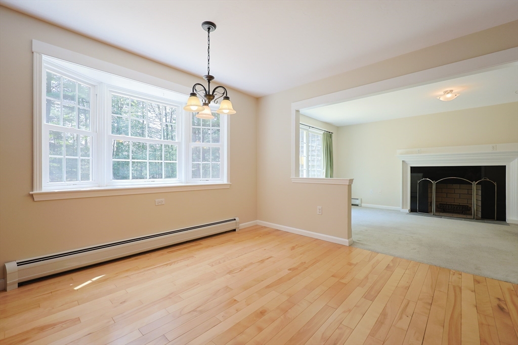 68 Dresser Hill Road, Unit 2 Dudley, MA 01571 - Photo 11 of 39 a view of empty room with wooden floor and fireplace
