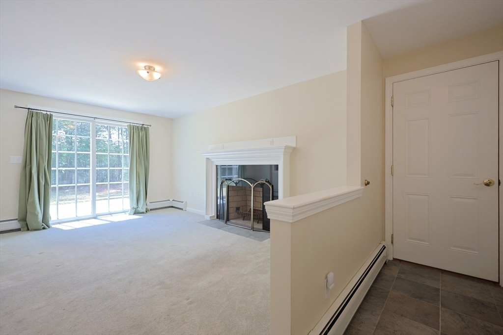 68 Dresser Hill Road, Unit 2 Dudley, MA 01571 - Photo 13 of 39 an empty room with a fireplace and a window