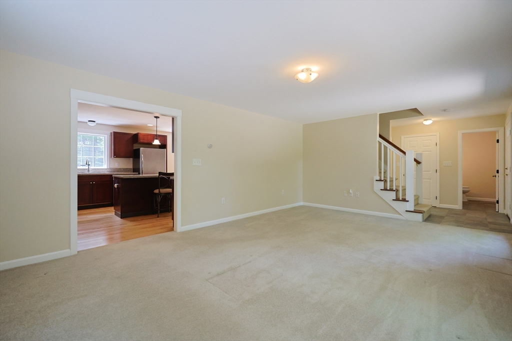 68 Dresser Hill Road, Unit 2 Dudley, MA 01571 - Photo 6 of 39 a view of an empty room with a fireplace and a cabinet