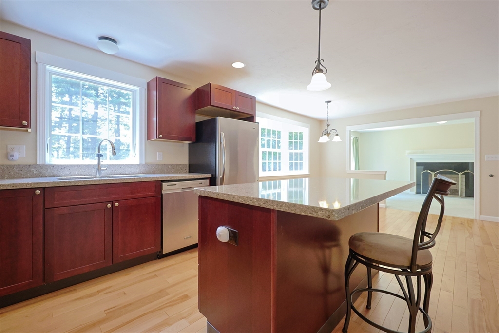 68 Dresser Hill Road, Unit 2 Dudley, MA 01571 - Photo 7 of 39 a kitchen with kitchen island a dining table chairs cabinets and a sink