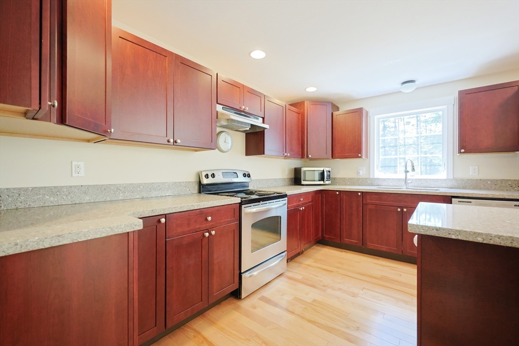 68 Dresser Hill Road, Unit 2 Dudley, MA 01571 - Photo 9 of 39 a kitchen with stainless steel appliances granite countertop a sink stove and refrigerator