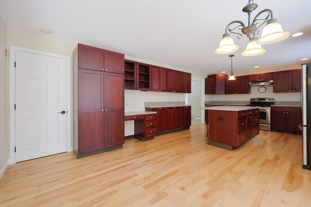 68 Dresser Hill Road, Unit 2 Dudley, MA 01571 - Photo 10 of 39 a large kitchen with stainless steel appliances granite countertop a stove and a wooden cabinets
