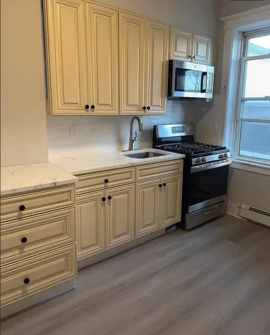 a kitchen with stainless steel appliances granite countertop a stove a sink and a microwave