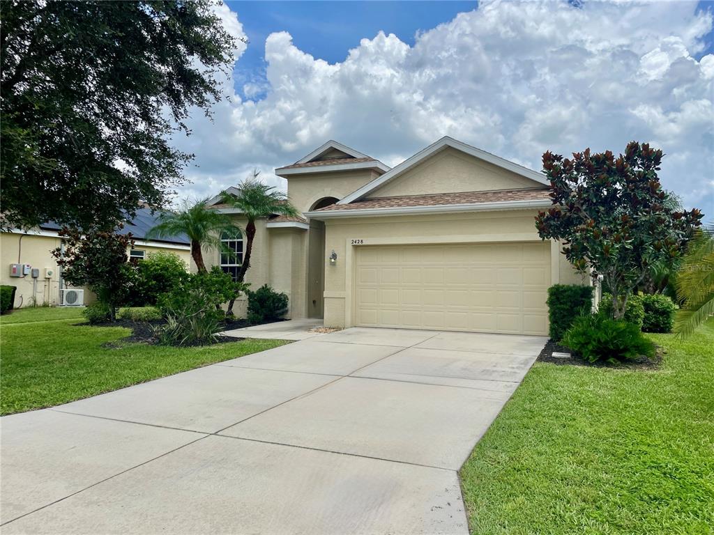 a front view of house with yard and green space