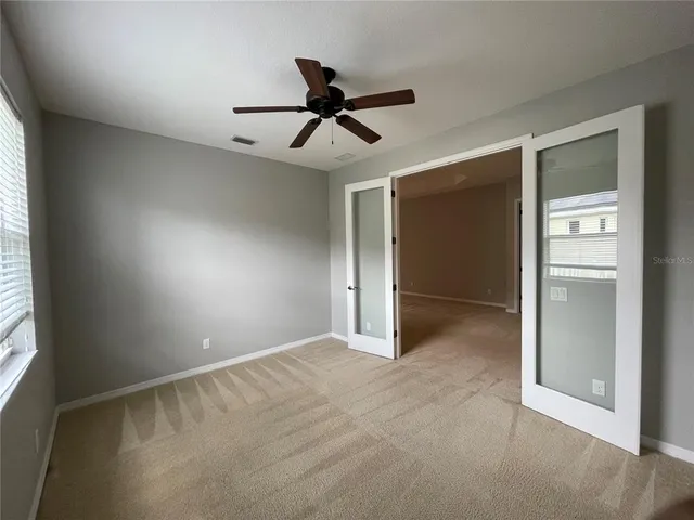 a view of a livingroom with a ceiling fan and window